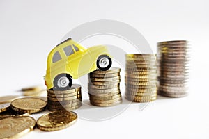 Rising cost of cars maintenance with small model car on cash stairs