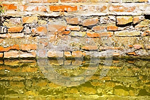 Rising damp on a brick wall in a channel full of water