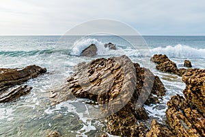 Rising surf breaking on rocky California shore