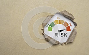 Risk level indicator rating inside punch brown paper from low to high on for business risk management analysis and assessment