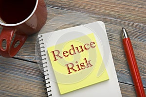 Risk management strategies - avoid, exploit, transfer, accept, reduce, ignore. Office desk table with notebook, pen and