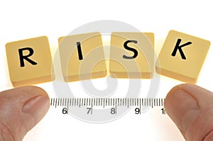 Risk measurement concept with letters and double decimeter on white background