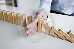 Risk and strategy in business, Close up of business woman hand stopping wooden block between three way from falling in the line of