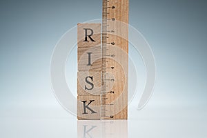 Risk Word On Blocks Near The Ruler On Reflective Desk