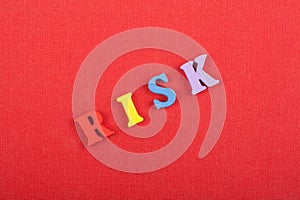 RISK word on red background composed from colorful abc alphabet block wooden letters, copy space for ad text. Learning english