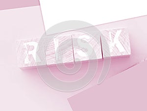 Risk Word On wooden cubes with pink wallet besides on pink background. Business startup risk and crisis management