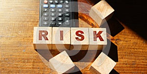 RISK word written on wooden cubes and calculator. business concept.