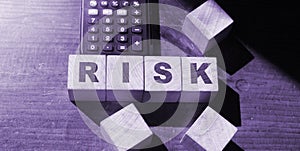 RISK word written on wooden cubes and calculator. business concept.