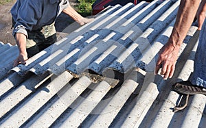 Risks of Asbestos Roofs, Asbestos Roof Removal. Asbestos removal roof works. House with old, danger asbestos roof tiles repair