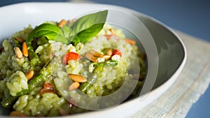 Risotto with green pesto. Risotto is a northern Italian rice dish cooked with broth until it reaches a creamy consistency.