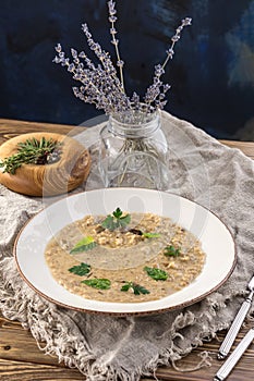 Risotto with porcini mushroom with basil and parsley serving size on wooden table