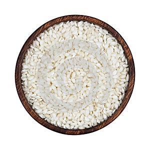 Risotto rice in wooden bowl isolated on white background. Top view