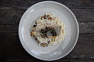 Risotto with sea bass fillet steak on wooden table , italian food