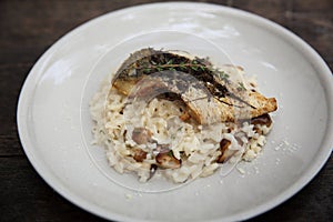 Risotto with sea bass fillet steak on wooden table , italian food