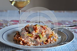 Risotto with vegetables zucchini, yellow pepper, red onion and some of tomato sauce ... with a glass of pinot grigio