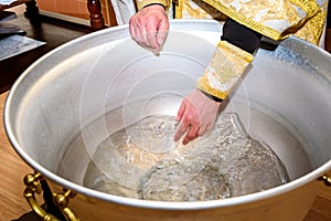 The rite of baptism. Priest prepare to baptize the child. Font for taking faith