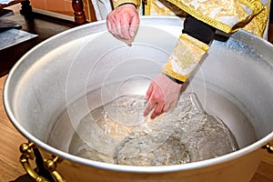 The rite of baptism. Priest prepare to baptize the child. Font for taking faith photo