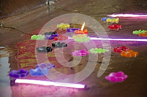 Ritual praying colorful candle floating on water for pray reclining Buddha image at Wat Phra Non Chakkrasi Worawihan in Sing Buri,