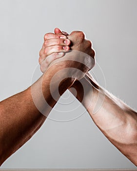 Rivalry, closeup of male arm wrestling. Muscular men measuring forces, arms. Hand wrestling, compete. Hands or arms of