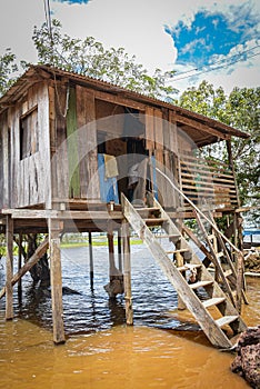 The River Amazon and houses on stilts on the river bank, a traditional Brazilian way to live near the river.