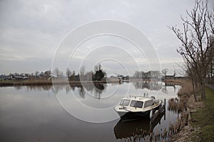 River amstel and small boat in winter not far from Amsterdam