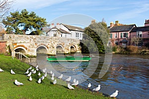 River Avon Christchurch Dorset England UK with bridge and green boat