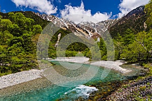 River Azusa flowing through the Kamikochi valley with snowy peaks (Kamikochi, Japan
