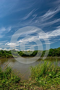 River bank and blue sky with clouds above it