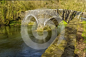 The river bank wall leads up to the Llawhaden bridge, that spans the River Cleddau, Wales