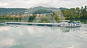 River barge cursing on the Rhone river on a cloudy day photo