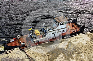 River barge loaded with sand. Close-up view of cargo ship barge loaded with sand. Top view of the front of the barge