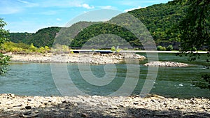 River barge passing behind the dry mud caked rocks of Rhine river during drought