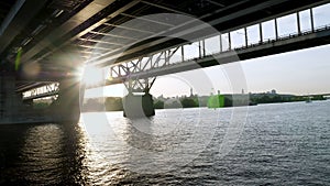 River barge sails under the bridge over the Dnieper in Kiev. Urban summer landscape.
