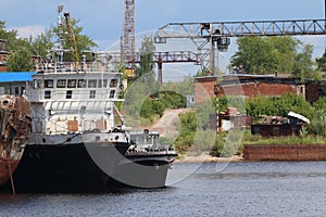 River bay with rusty cargo ships on sunny day