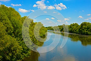 River, blue sky, white clouds and green trees. nature in summer.