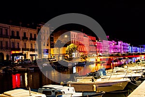 River with boats in a city in southern France at night