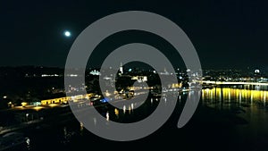 River and bridge in city, night aerial view