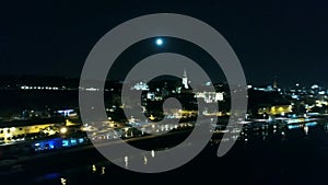 River and bridge in city, night aerial view