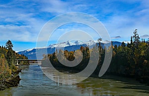 River, bridge and forests with snow capped mountains