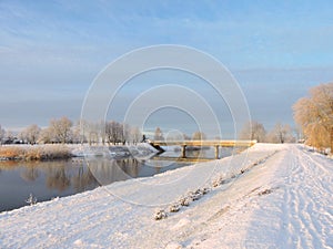 River, bridge and snowy winter trees in Rusne island, Lithuania