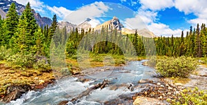 River in Canadian Rockies during sunny cloudy day. Banff, Alberta, Canada