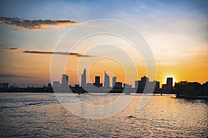 River city view landscape at twilight sunset. Boat on river with tranquil water. Hochiminh city Saigon vietnam cityscape building