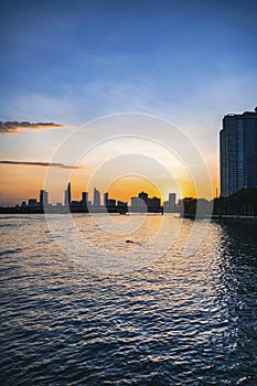 River city view landscape at twilight sunset. Boat on river with tranquil water. Hochiminh city Saigon vietnam cityscape building