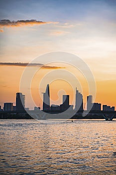 River city view landscape at twilight sunset. Boat on river with tranquil water. Hochiminh city Saigon vietnam cityscape building