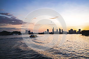 River city view landscape at twilight sunset. Boat on river with tranquil water. Hochiminh city Saigon vietnam cityscape building