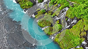 River with clear glacial water, Mountain waterfall surrounded by dense green trees and bushes, Turquoise colored water