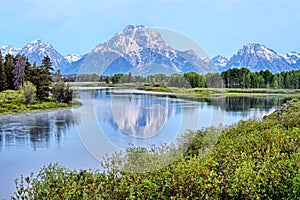 A river in Colorado reflects snow capped mountains. photo