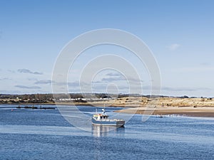 River Coquet at Amble, Northumberland, UK with fishing boat, beach and copy space