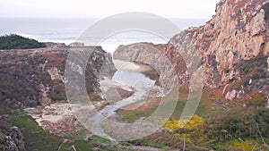 River creek estuary in canyon, mountain cliff or bluff. California ocean coast.