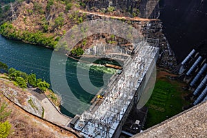 River dam amidst beautiful landscape with bridge, mountains and trees in summer, power plant at Bhumibol Dam in Thailand